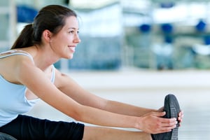 Woman doing stretching exercises for her leg at the gym Woman doing stretching exercises for her leg at the gym