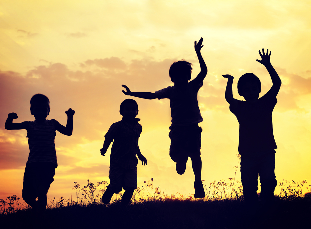 Children playing on summer sunset meadow